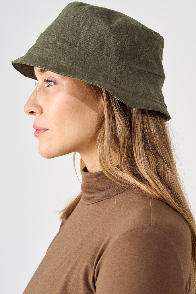 Woman wearing olive linen bucket hat. 