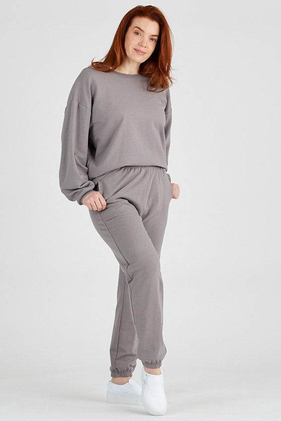 Woman wearing bamboo fleece sweatpants in grey, Canadian made women's loungewear, standing