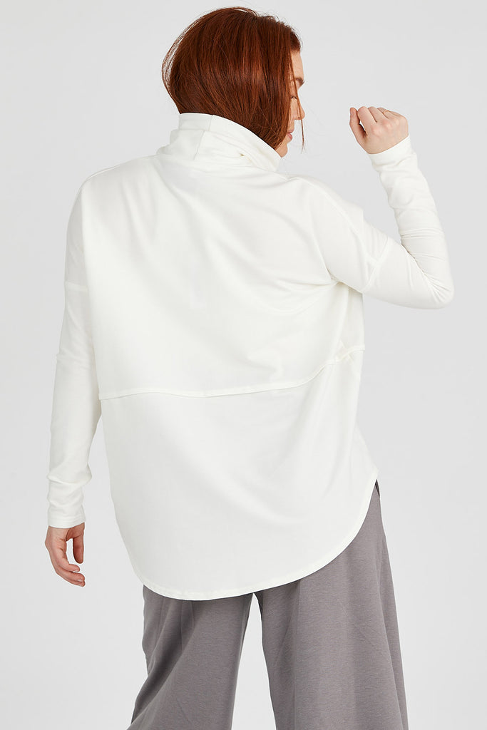 Back view of woman wearing ivory Tencel oversized turtleneck, made by Canadian loungewear label Advika. 