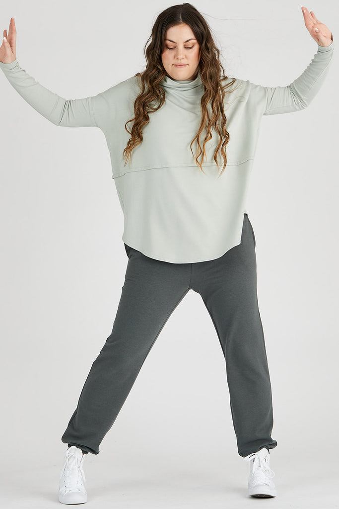 Woman wearing light green sage Tencel oversized turtleneck, made by Canadian loungewear label Advika. 