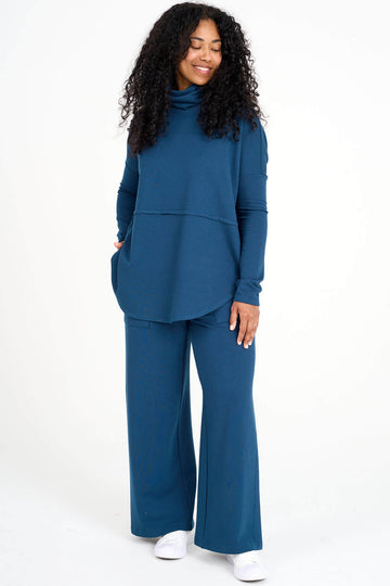 Woman wearing blue Tencel oversized Abigail turtleneck with matching palazzo pants, made by Canadian loungewear label Advika. 