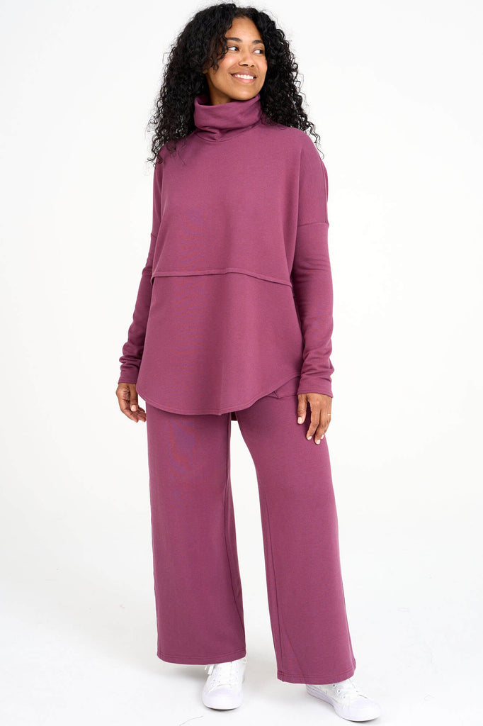 Woman wearing raspberry pink Tencel oversized Abigail turtleneck with matching palazzo pants, made by Canadian loungewear label Advika. 
