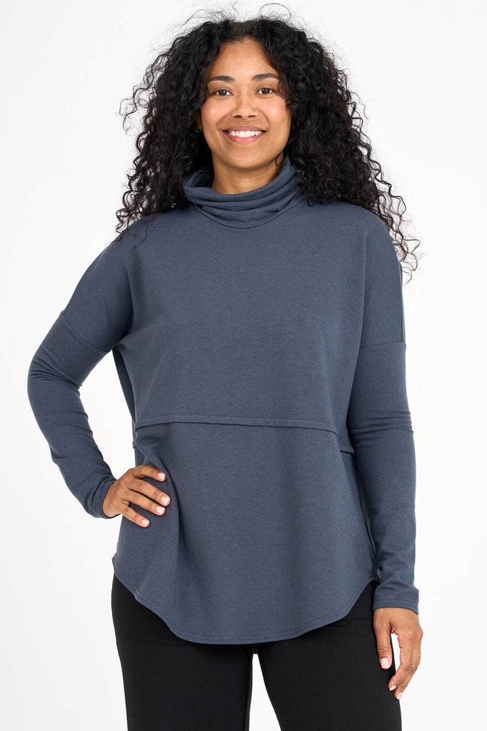 Woman wearing steel blue Tencel oversized turtleneck, made by Canadian loungewear label Advika. 