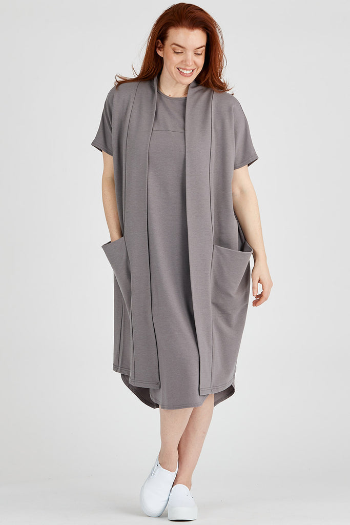 Woman wearing grey tencel blend Aiken midi dress with curved hem and matching long cardigan, made by Canadian loungewear label Advika.