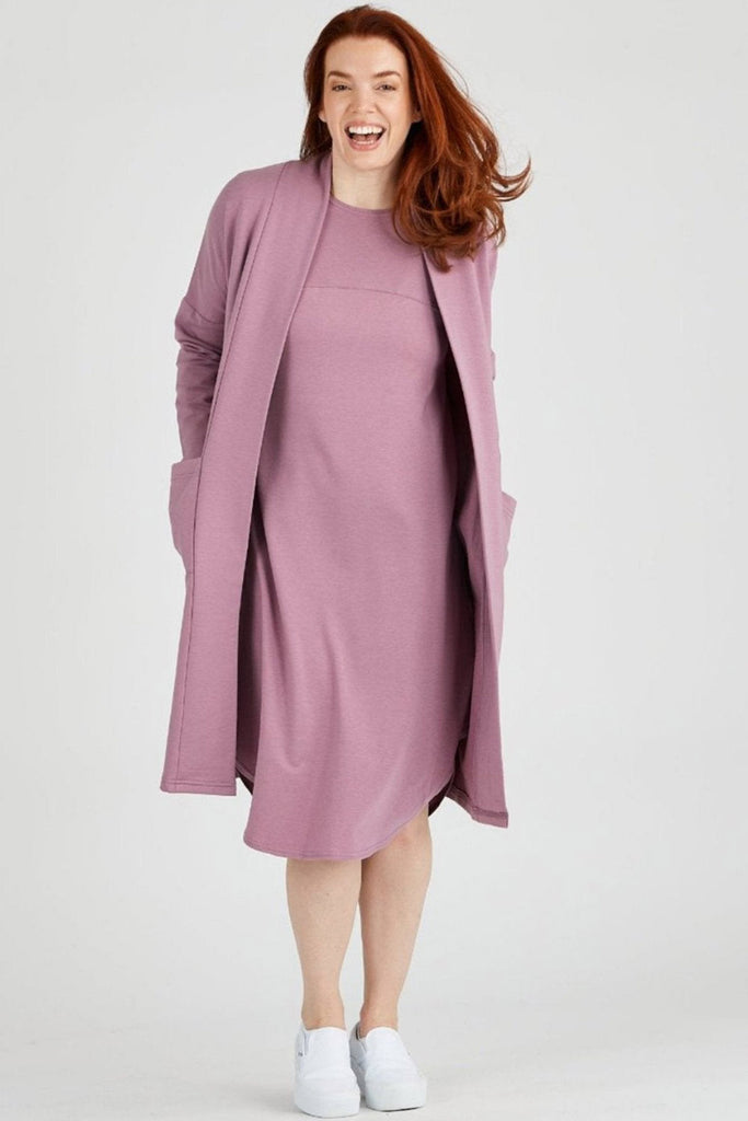 Woman wearing mauve tencel blend Aiken midi dress with curved hem and matching long cardigan, made by Canadian loungewear label Advika.