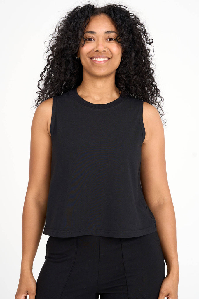Woman wearing black tencel cropped tank top by Canadian loungewear label Advika. 