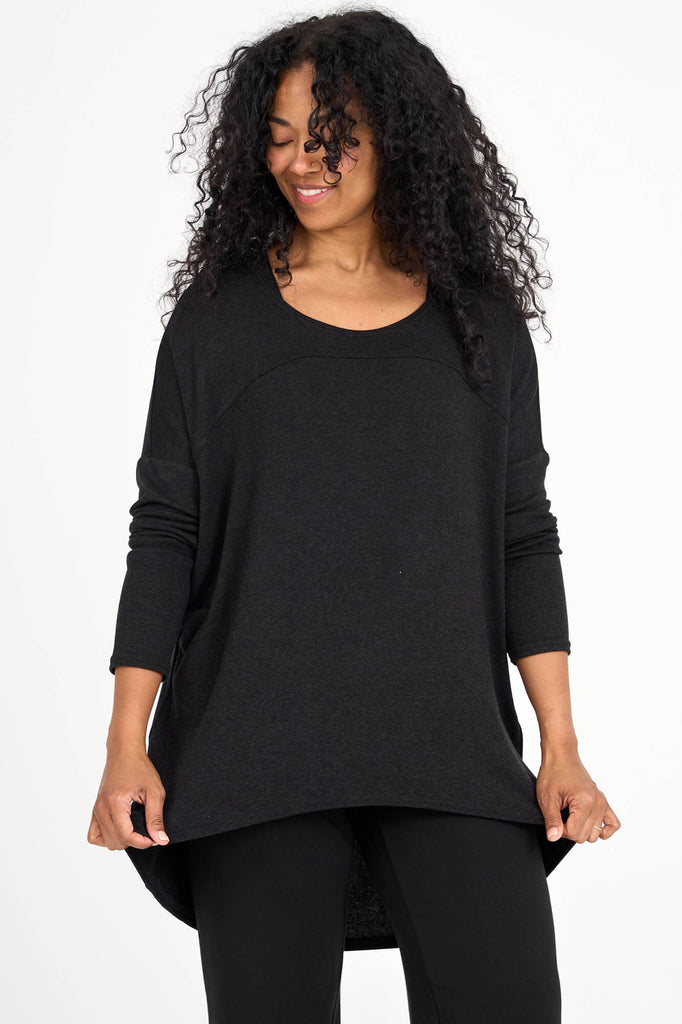 Woman wearing black Tencel long sleeve slouchy top with back pleat detail, made by Canadian loungewear label Advika. 