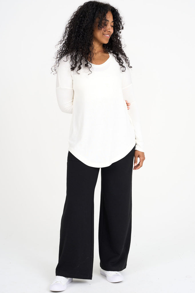 Woman wearing white Amelia top with black tencel wide leg loungewear palazzo pants by Advika. 