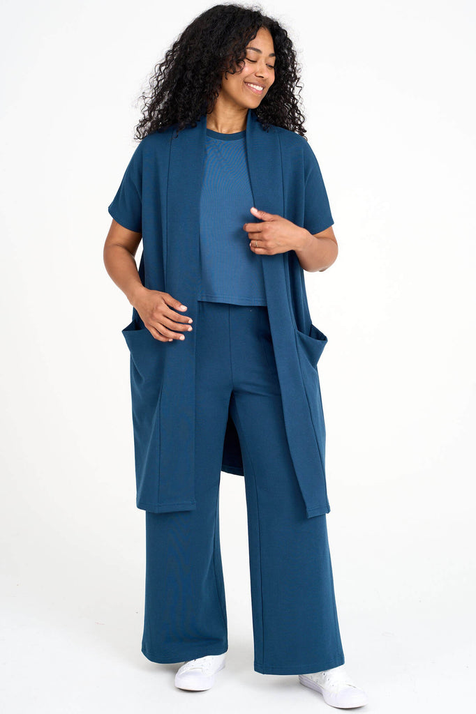 Woman wearing bluebell blue tencel open front short sleeve duster cardigan and matching palazzo pants by Canadian loungewear designer Advika. 
