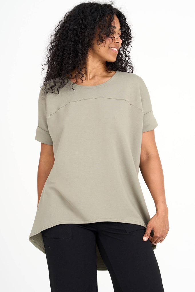 Woman wearing eucalyptus green Tencel short sleeve slouchy top with back pleat detail, made by Canadian loungewear label Advika. 