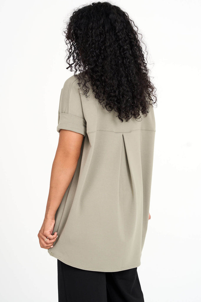 Back view of woman wearing eucalyptus green Tencel short sleeve slouchy top with back pleat detail, made by Canadian loungewear label Advika. 