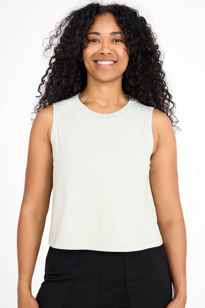Woman wearing light sage green tencel cropped tank top by Canadian loungewear label Advika. 
