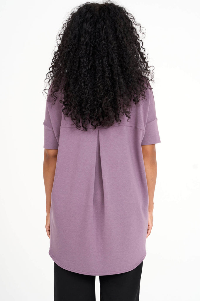 Back view of woman wearing mauve Tencel short sleeve slouchy top with back pleat detail, made by Canadian loungewear label Advika. 