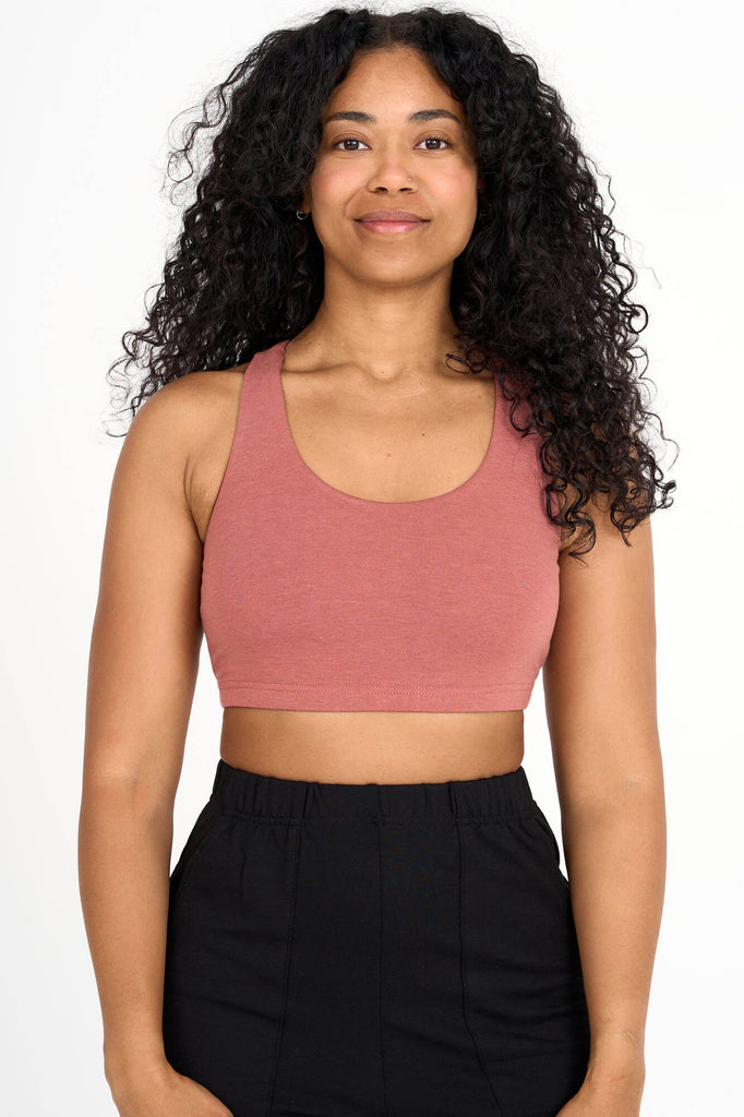 Woman wearing light brick pink Tencel blend sports bra, made by Canadian loungewear label Advika.