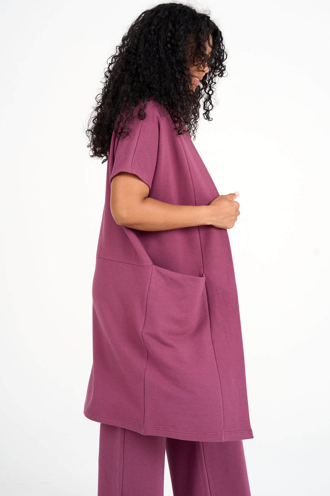 Side view of woman wearing raspberry pink tencel open front short sleeve duster cardigan by Canadian loungewear designer Advika. 