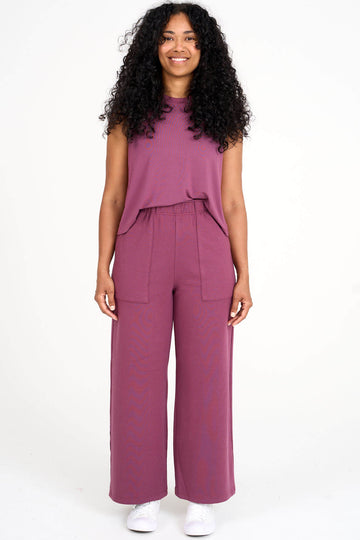 Woman wearing raspberry pink Breathe tank tucked into matching tencel wide leg loungewear palazzo pants by Advika. 