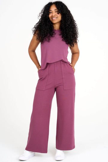 Woman wearing raspberry pink Breathe tank tucked into matching tencel wide leg loungewear palazzo pants by Advika. 