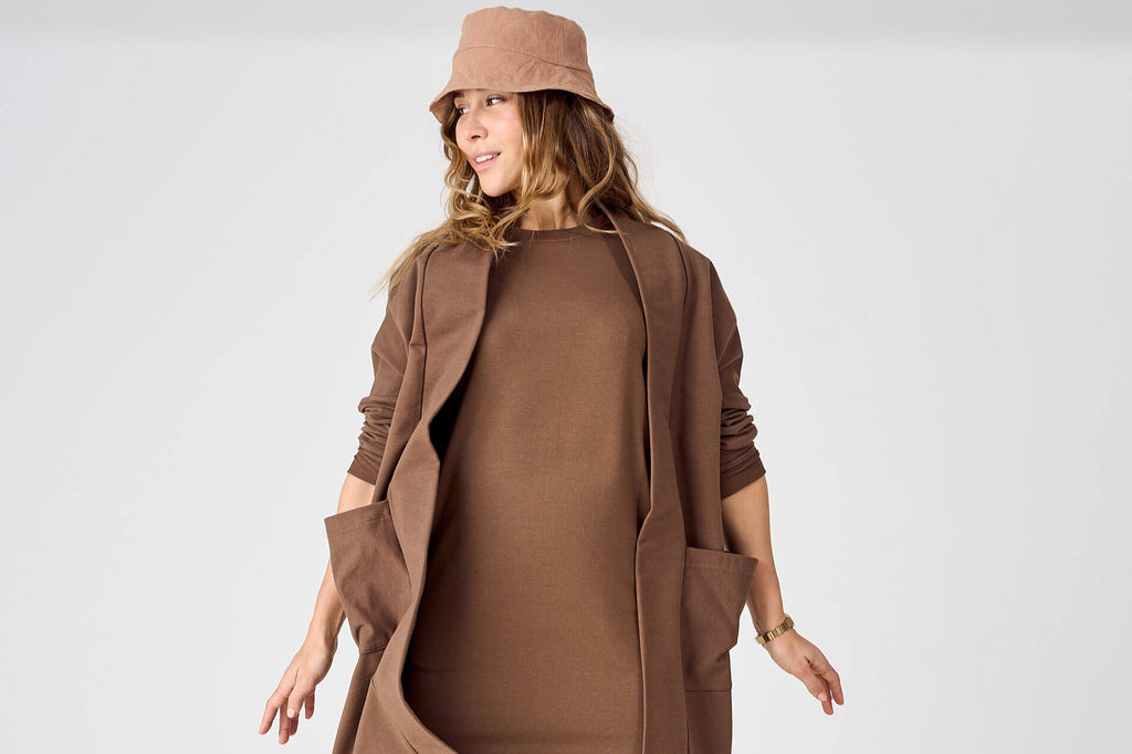Woman wearing brown tencel t-shirt dress, open front long duster cardigan and matching bucket hat by Advika. 