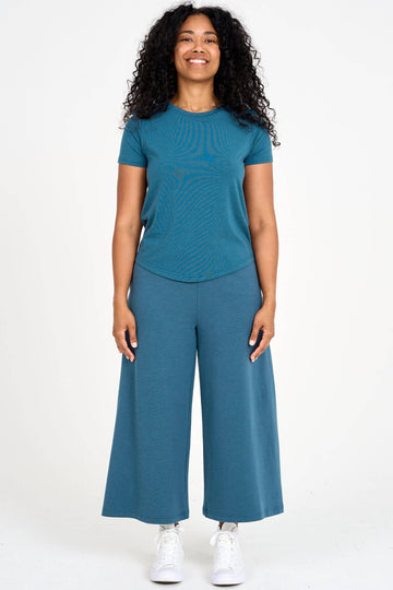 Woman wearing dusty teal Tencel blend wide leg gaucho pants with matching t-shirt, made by Canadian loungewear label Advika.