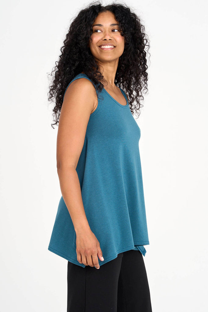 Side view of woman wearing dusty teal Tencel flared tank top, made by Canadian loungewear label Advika. 