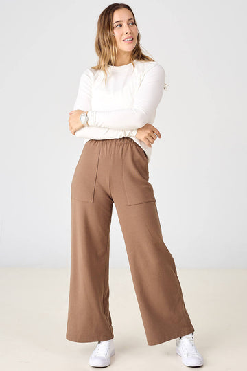 Woman wearing light creamy brown tencel palazzo pants by Advika. 