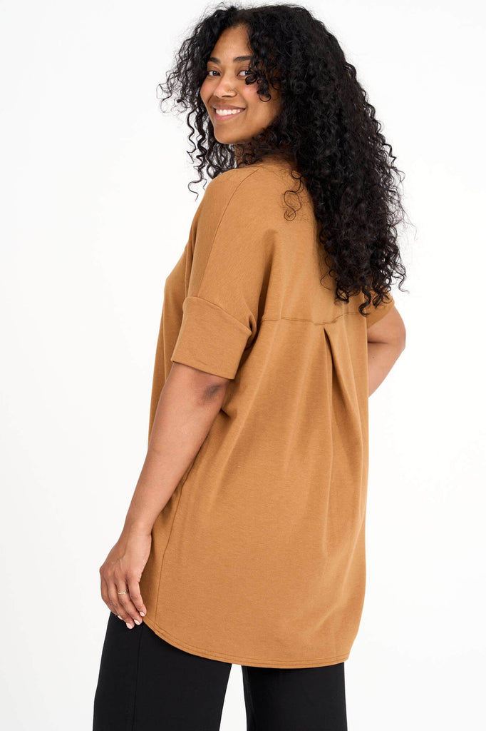 Back view of woman wearing whiskey yellow Tencel short sleeve slouchy top with back pleat detail, made by Canadian loungewear label Advika. 