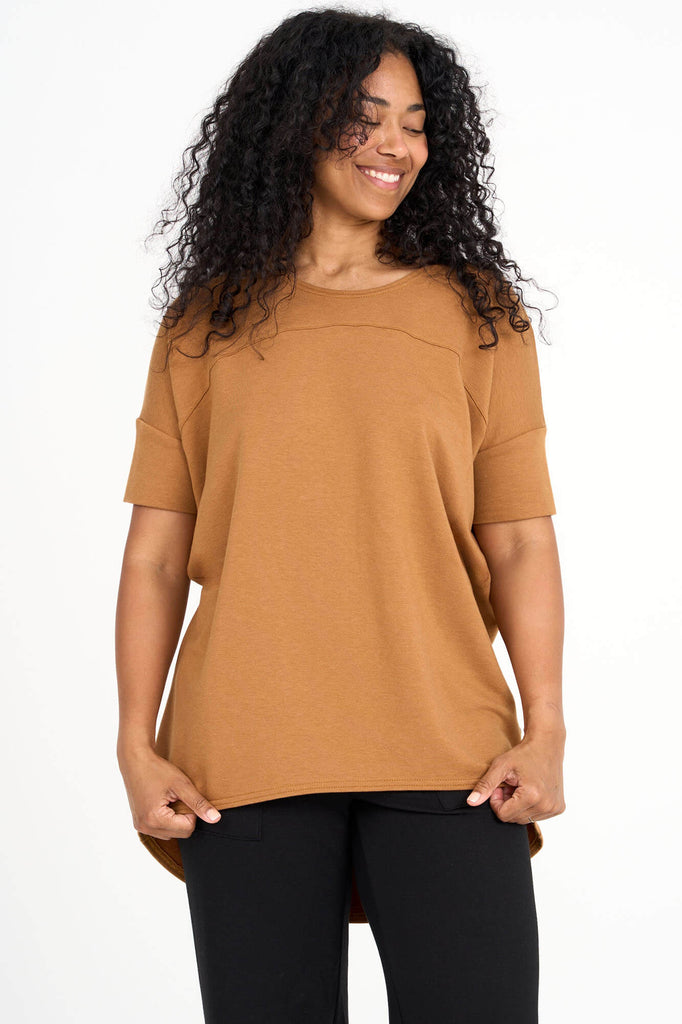 Woman wearing whiskey yellow Tencel short sleeve slouchy top with back pleat detail, made by Canadian loungewear label Advika. 