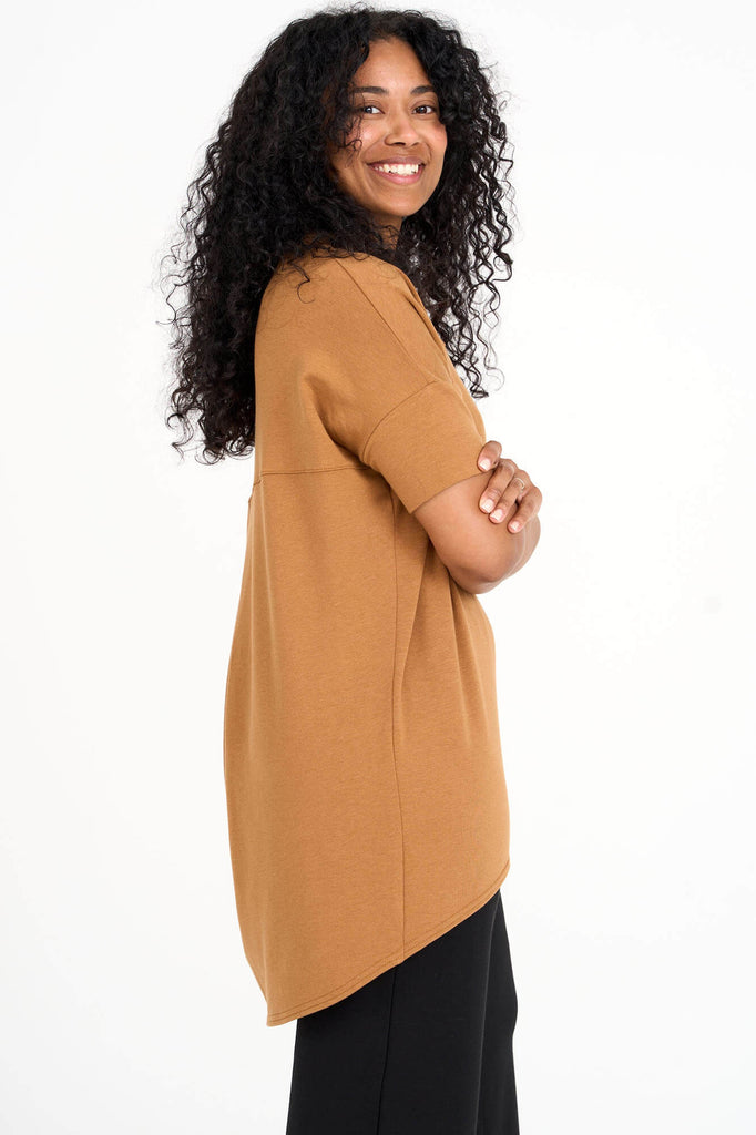 Side view of woman wearing whiskey yellow Tencel short sleeve slouchy top with back pleat detail, made by Canadian loungewear label Advika. 