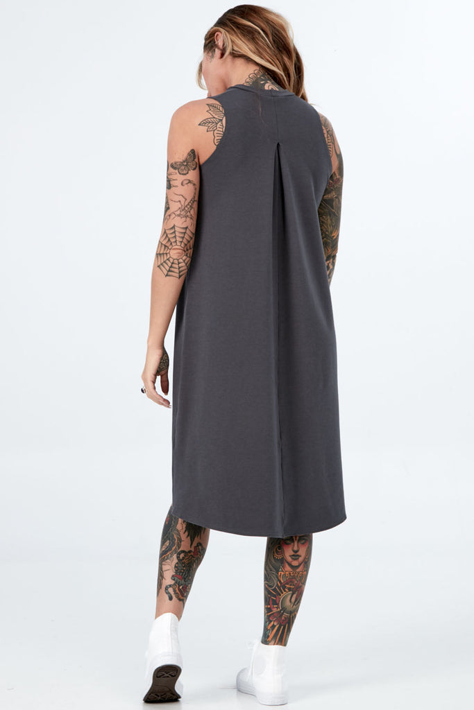 Woman wearing Tencel mock neck sleeveless dress, Canadian made women's loungewear, standing back