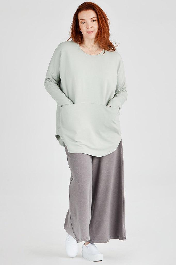 Woman wearing Tencel oversized top with pockets in sage, Canadian made women's loungewear, front